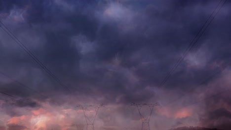 animation of storm with blue lightnings and grey clouds over electric pylons