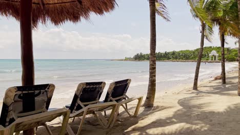 tulum cancun méxico trs beach resort mostrando las cabañas con mesas, sillas y palmeras