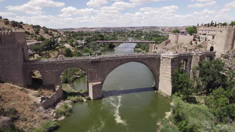 Historic-medieval-bridge-Puente-de-San-Martin,-aerial-orbit