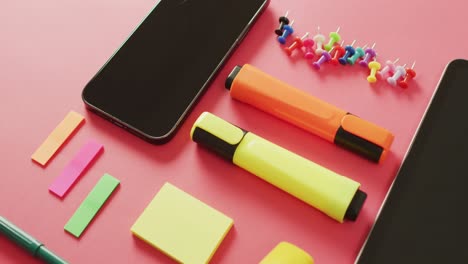 video de composición de artículos escolares, teléfono inteligente y tableta con espacio de copia en superficie rosa
