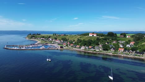 isla de ven, suecia: video de un avión no tripulado dando vueltas alrededor del puerto de la aldea de kyrkbacken en una soleada mañana de verano