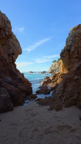 breathtaking view of a small cove with red rocks and turquoise water vertical video
