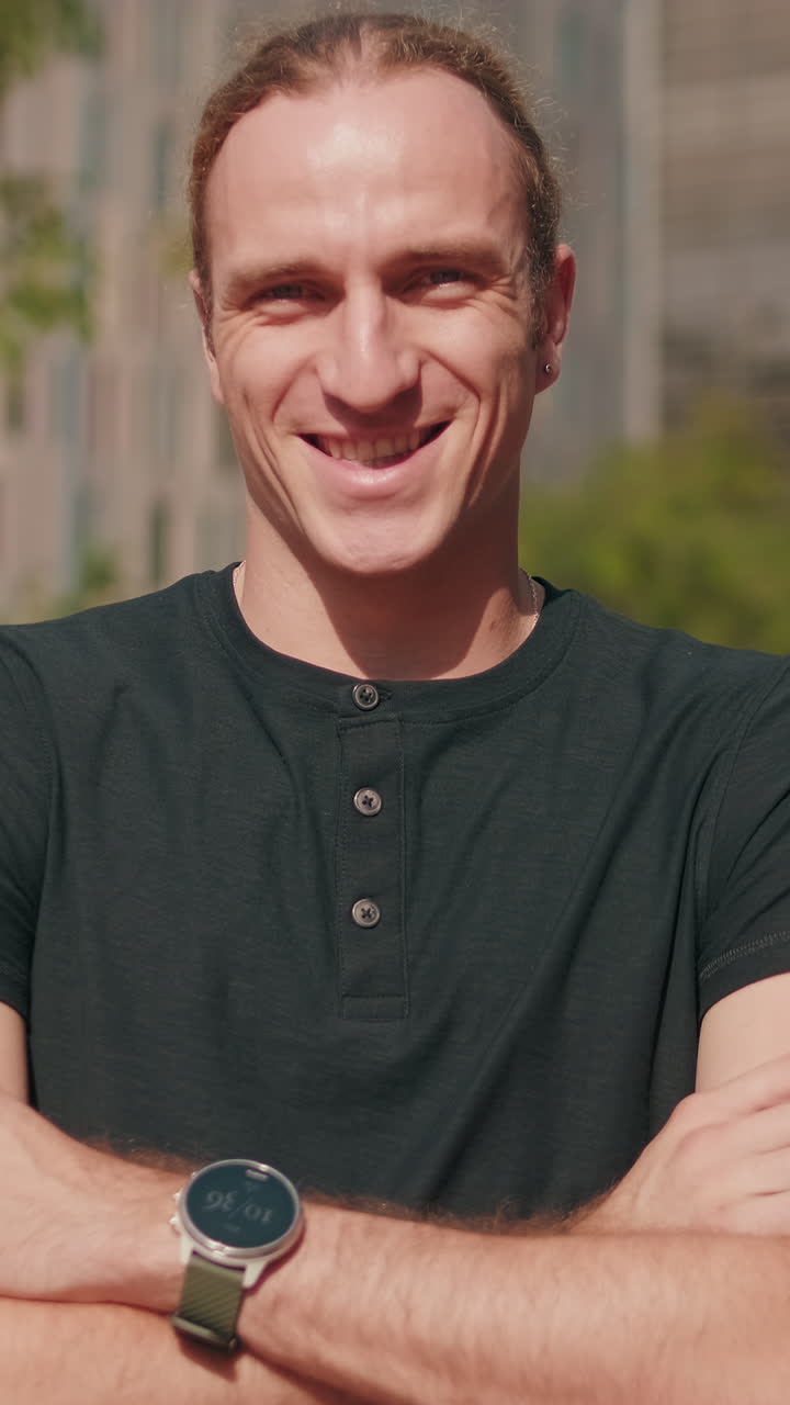 Portrait of handsome European boy with his arms crossed, male student outdoors