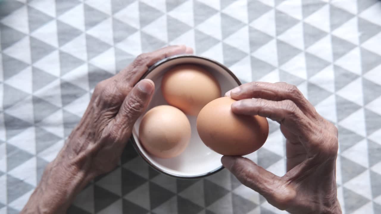 Elderly hands preparing eggs