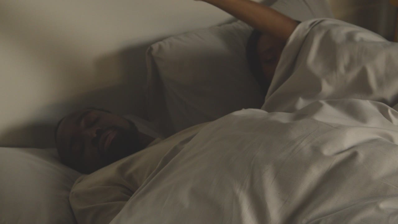 Close Up Of Loving Couple Lying Asleep In Bed At Home At Night