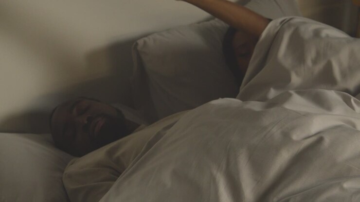 Close Up Of Loving Couple Lying Asleep In Bed At Home At Night