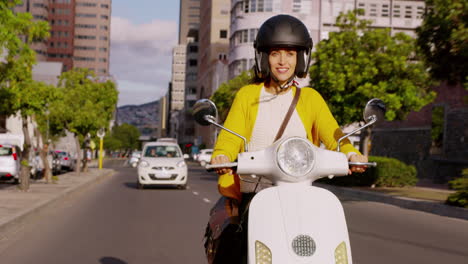 mujer montando un scooter en una calle de la ciudad