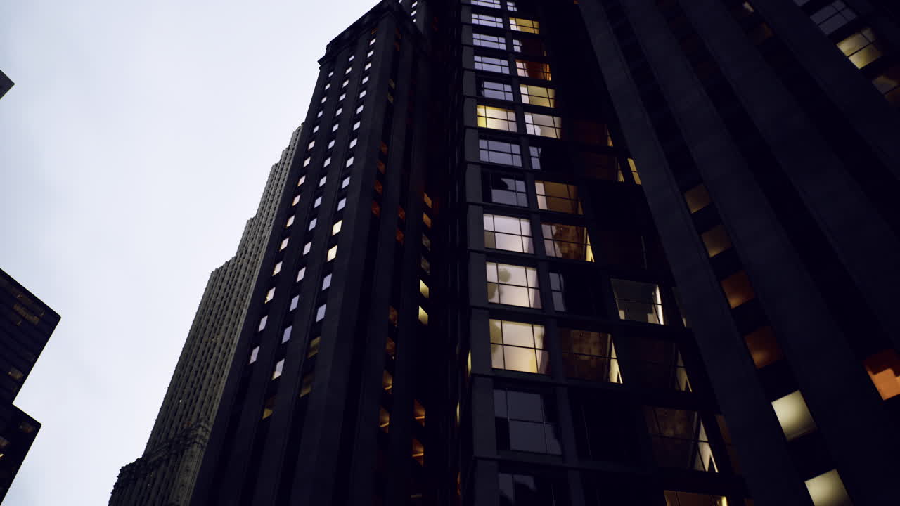 Tall buildings illuminated at dusk in a bustling urban area