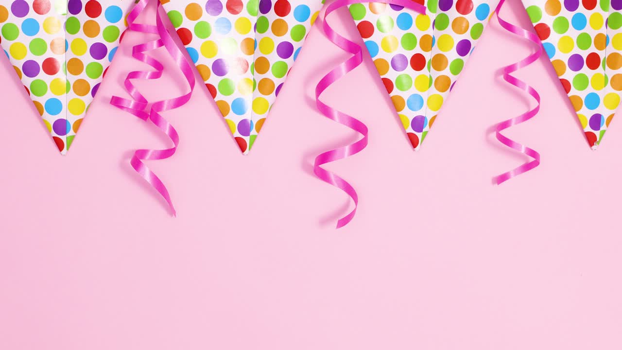Party decorations with flag banners and ribbons on pastel pink theme. Stop motion