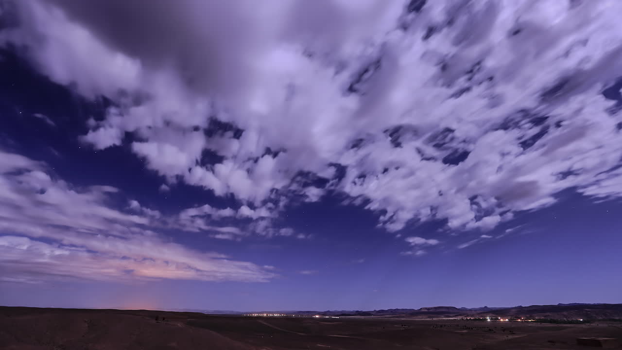 lapso de tiempo de un paisaje plano bajo un cielo azul con las nubes blancas deslizándose rápidamente
