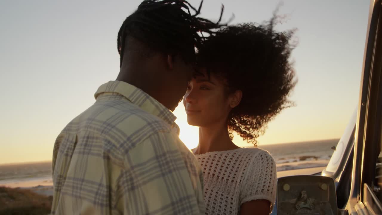 Couple embracing each other near pickup truck at beach 4k