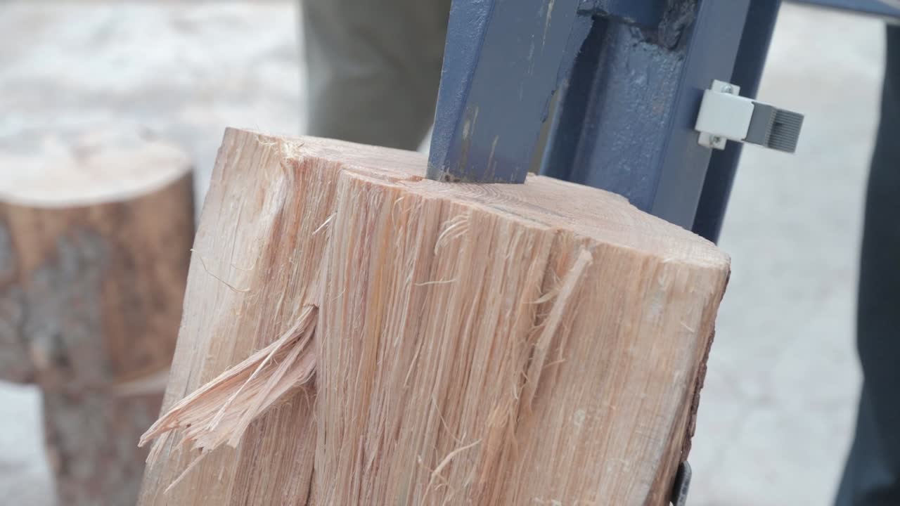 Homemade industrial machine slicing through a firewood log