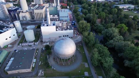 large round gas storage tank on the site of a large power station in the german city of braunschweig on the river oker