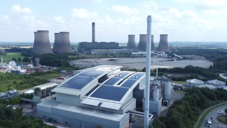 Saubere-Solardachanlage-Auf-Modernem-Bürogebäude-Luftaufnahme-Mit-Kohlekraftwerk-Im-Hintergrund-Langsamer-Abstieg