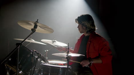 Young-male-drummer-playing-drums-at-music-studio