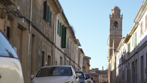 narrow street in a spanish town with a bell tower