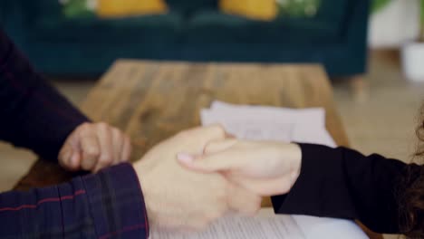 close-up shot of male hand signing buy and sell contract and getting house keys from housing agent then shaking hands. selling and buying real estate concept.