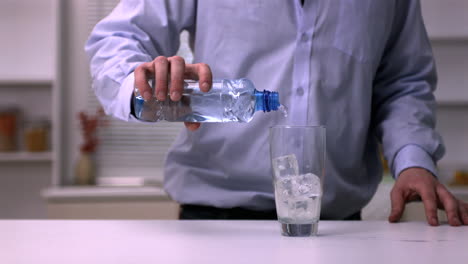 man pouring water into a glass