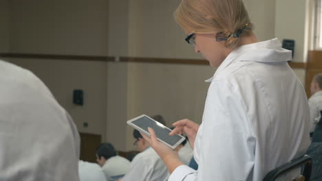 Estudiante-De-Medicina-Tomando-Notas-En-La-Libreta-Durante-La-Conferencia