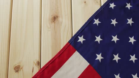 acercamiento de la bandera estadounidense con estrellas y rayas sobre fondo de madera