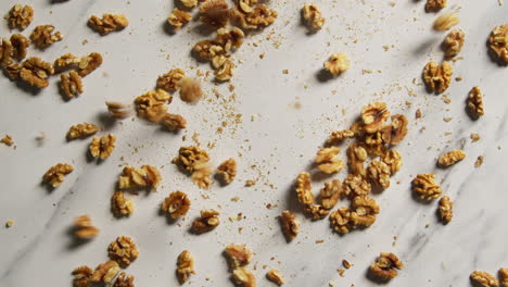 overhead shot of walnuts dropping onto marble surface shot in slow motion