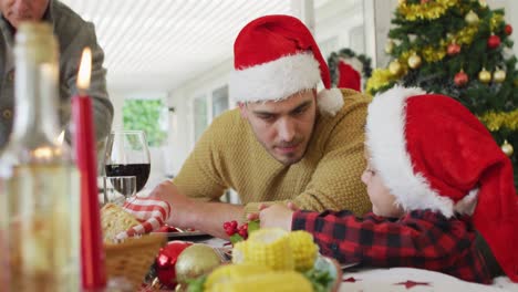 caucasian father and son talking at christmas table