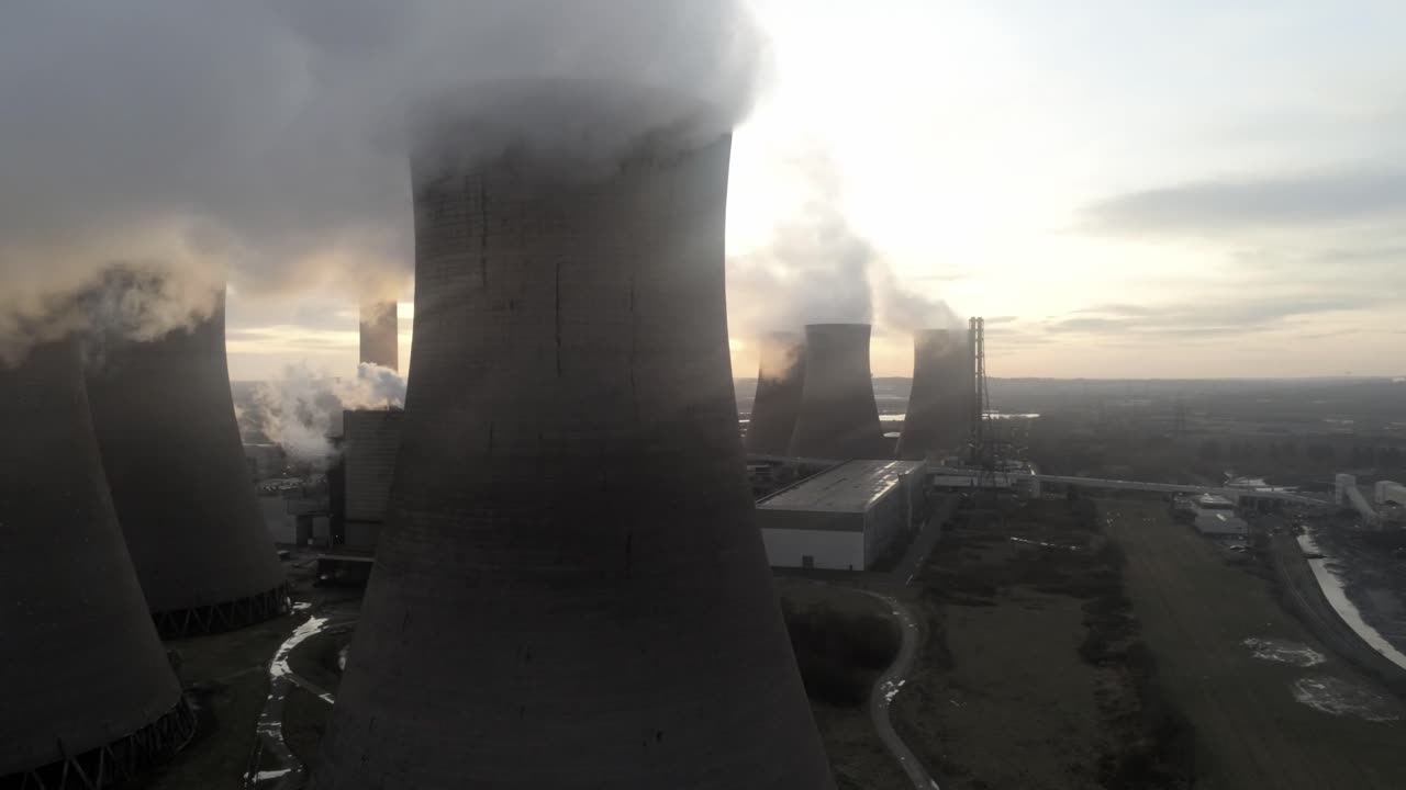 vista aérea del amanecer saliendo de detrás de las torres de refrigeración de la central eléctrica del reino unido las emisiones de vapor de humo