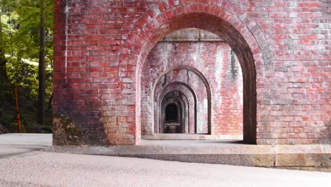 Slide-shot-looking-through-under-the-brick-bridge-in-Kyoto,-Japan-4K-slow-motion-left-to-right