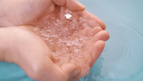 el agua potable fluye en las palmas de las manos de la mujer. filmado con una cámara súper lenta de 1000 fps.