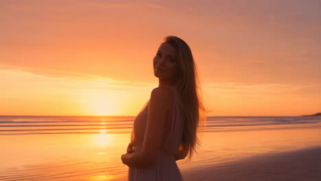 woman in dress on beach at sunset
