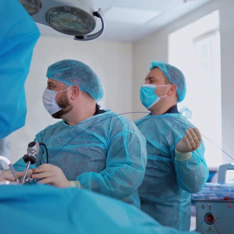 surgery operation conducted by two doctors in hospital. surgeons perform an operation using modern device for crushing stones in kidneys. operating theatre.