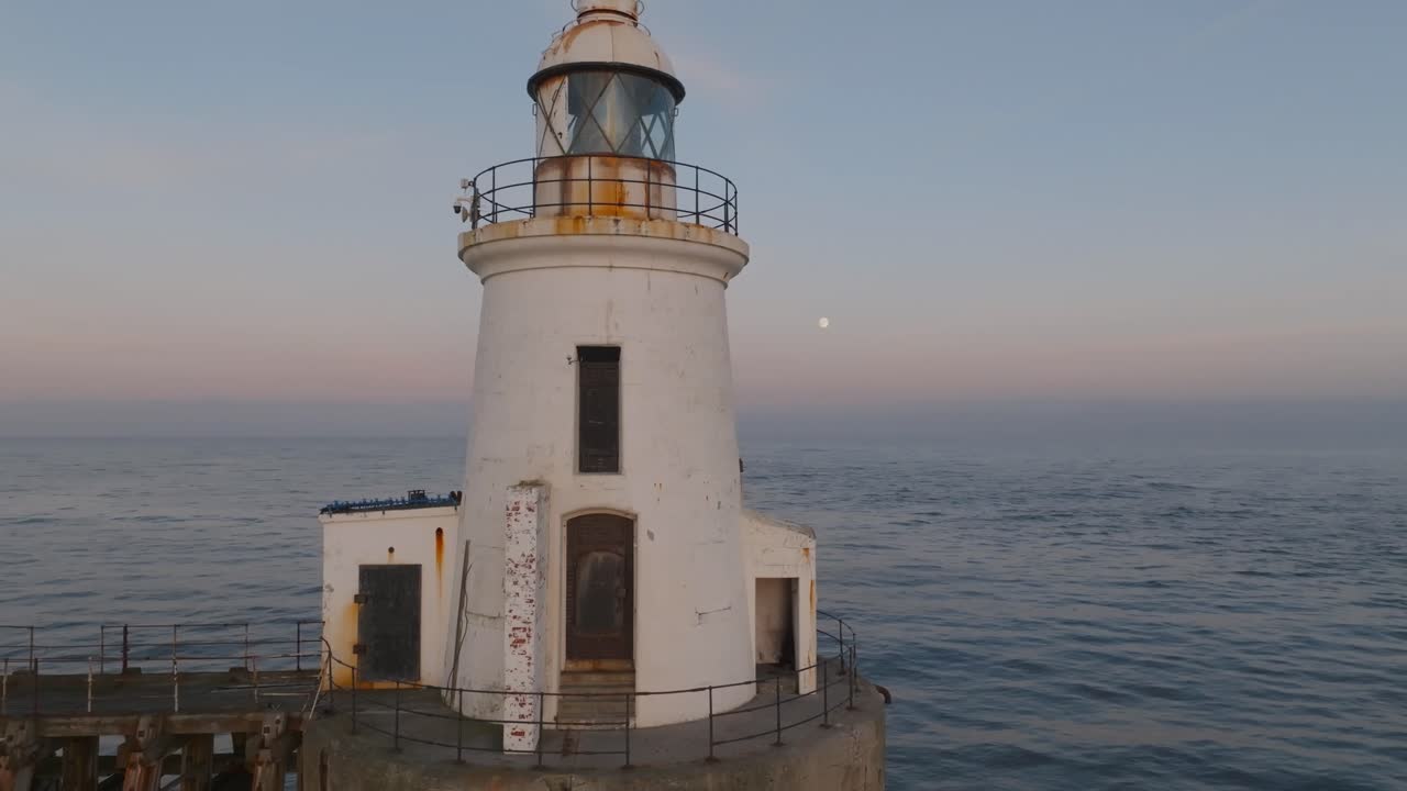 A breathtaking aerial view of Blyth Lighthouse illuminated by the rising full moon at twilight, marking the serene entrance to Blyth Harbour.