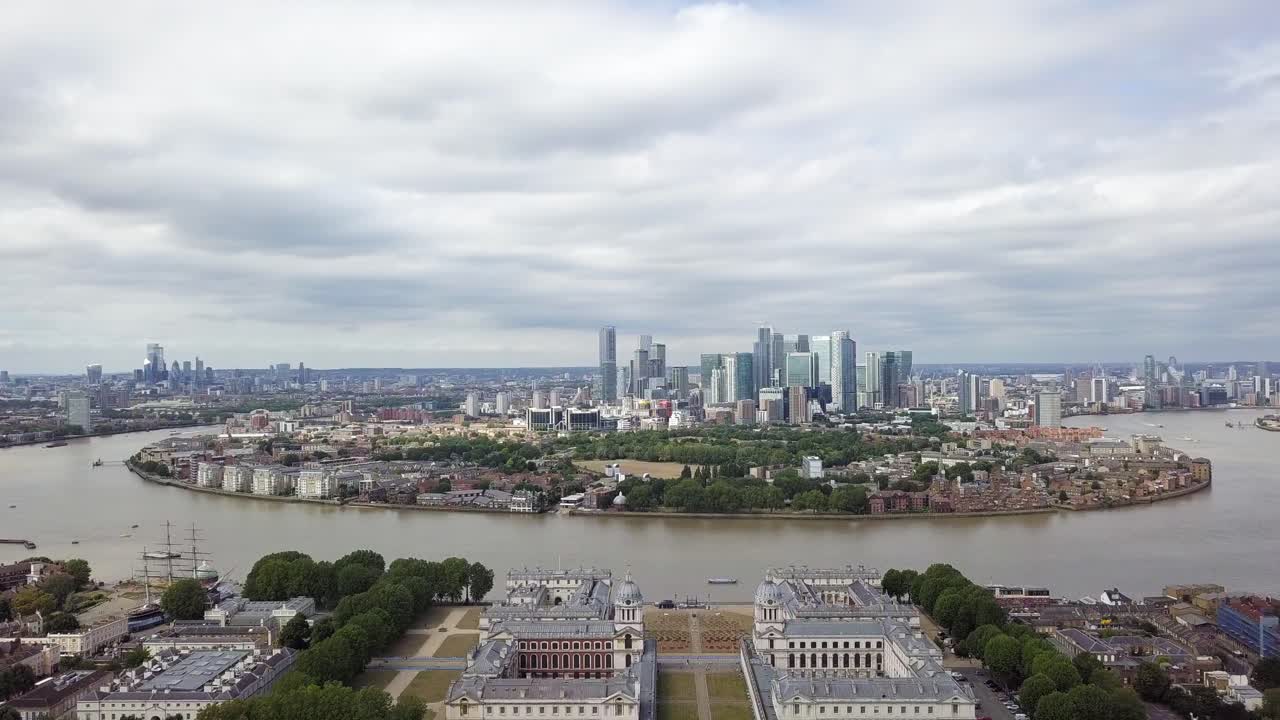 An elevating aerial drone view of Isle of Dogs from Greenwich observatory park during a cloudy grey weather