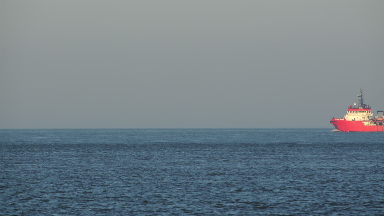 shot captures the offshore supply vessel, Putford Jaguar, as it head out to sea next to the offshore wind turbines at Scroby Sands Wind Farm.