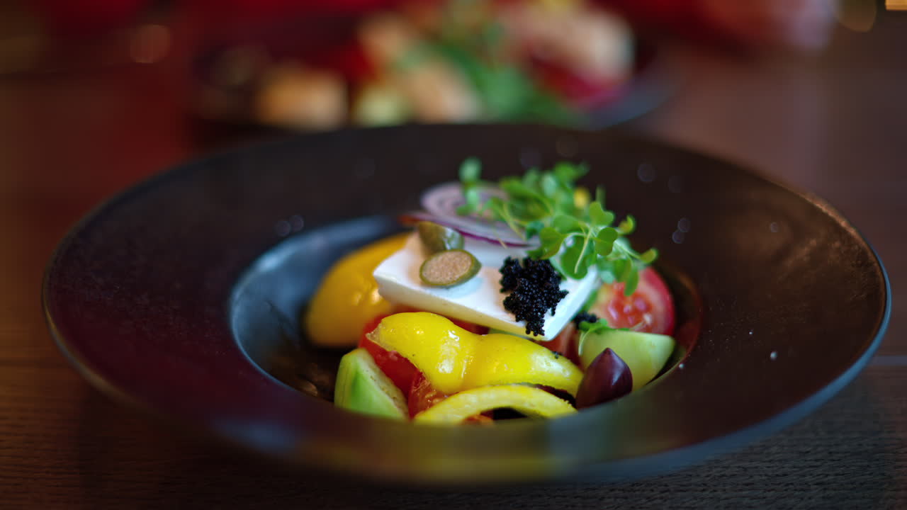 Woman in red sweater eating greek salad with vegetables