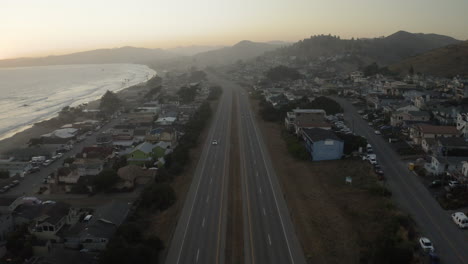 aerial view of a coastal highway running through a town at dusk