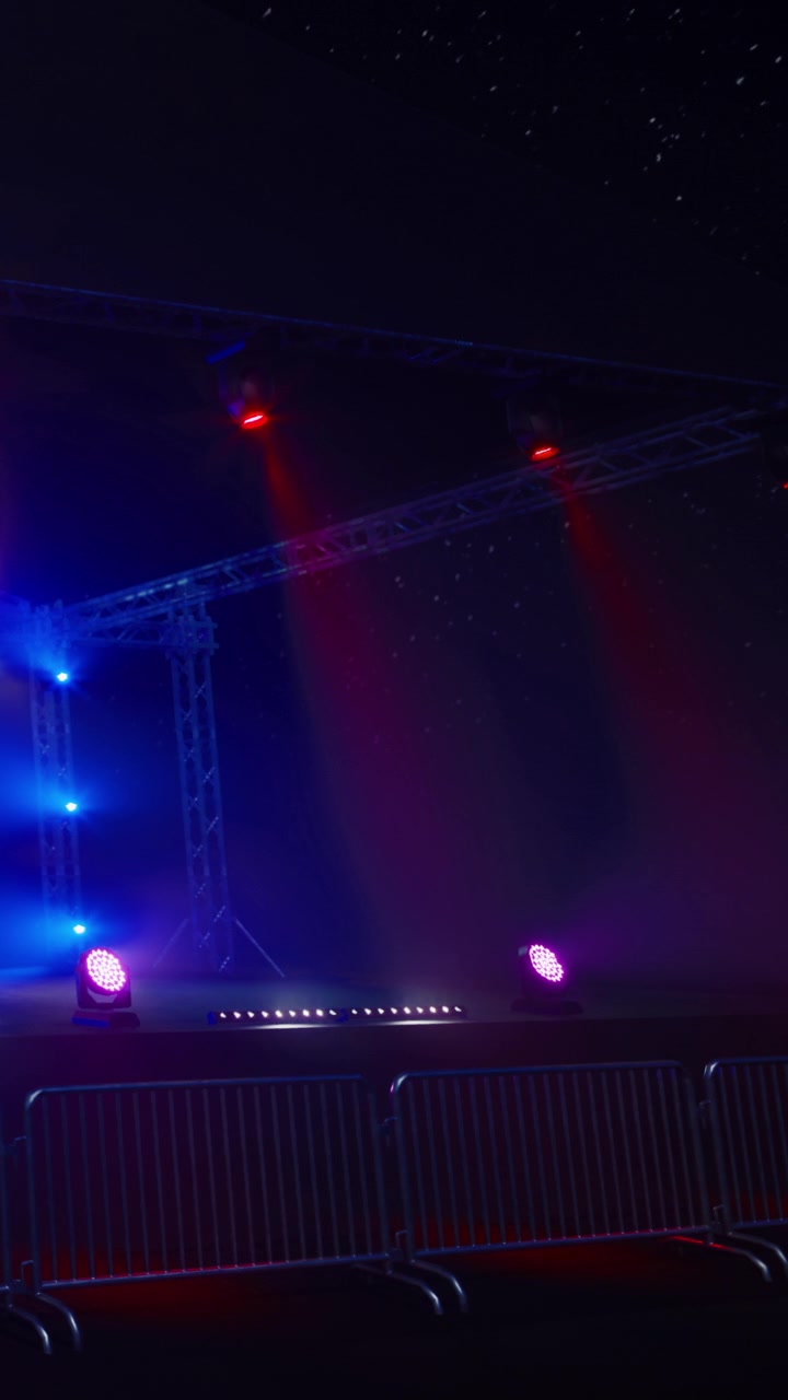 Stage setup with colorful lights and barriers for an event or performance