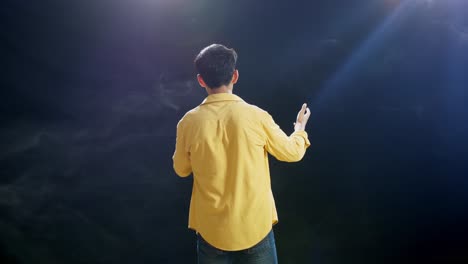 vista trasera de un niño con un micrófono en la mano y rap en el fondo blanco de humo negro