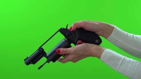 close up of woman checking handgun for ammo, cocking, de-cocking on green screen