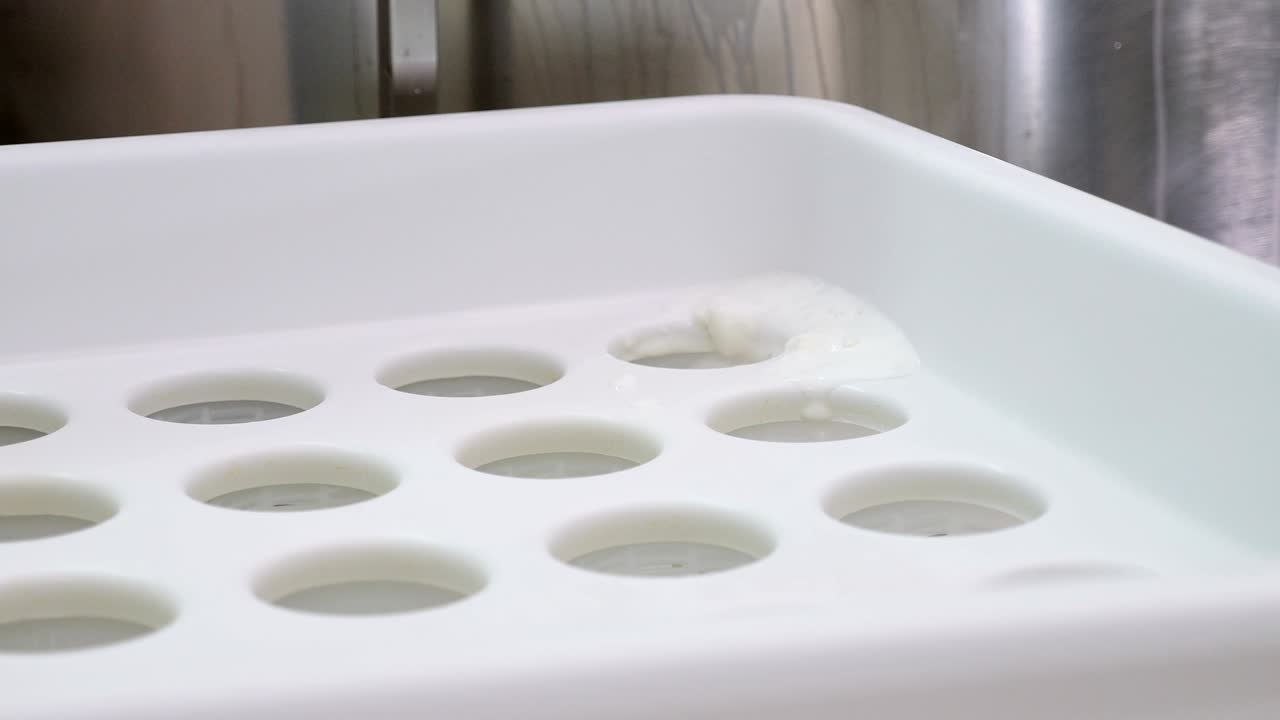 puesta de leche fresca en los moldes- producción de queso ricotta