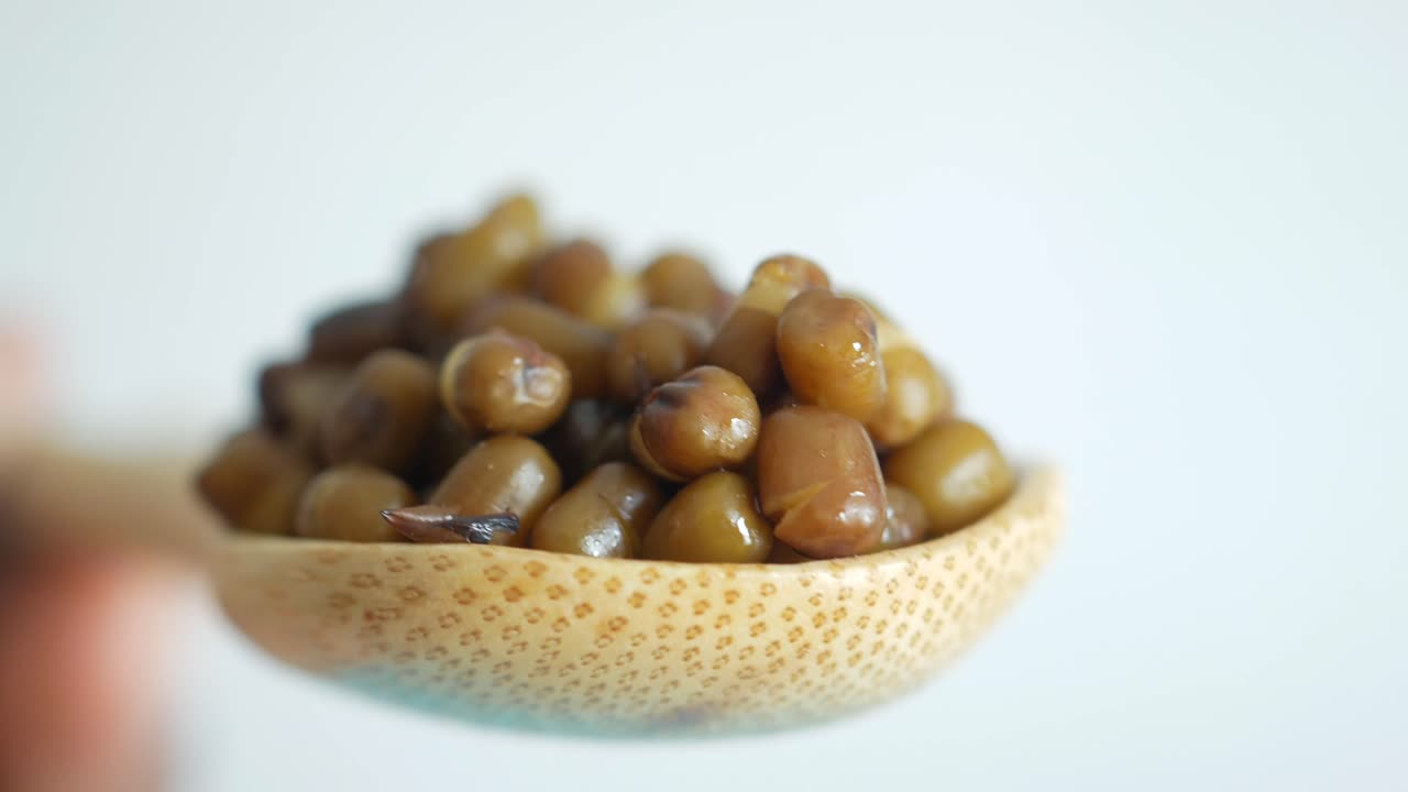 Closeup of cooked mung beans in a wooden spoon