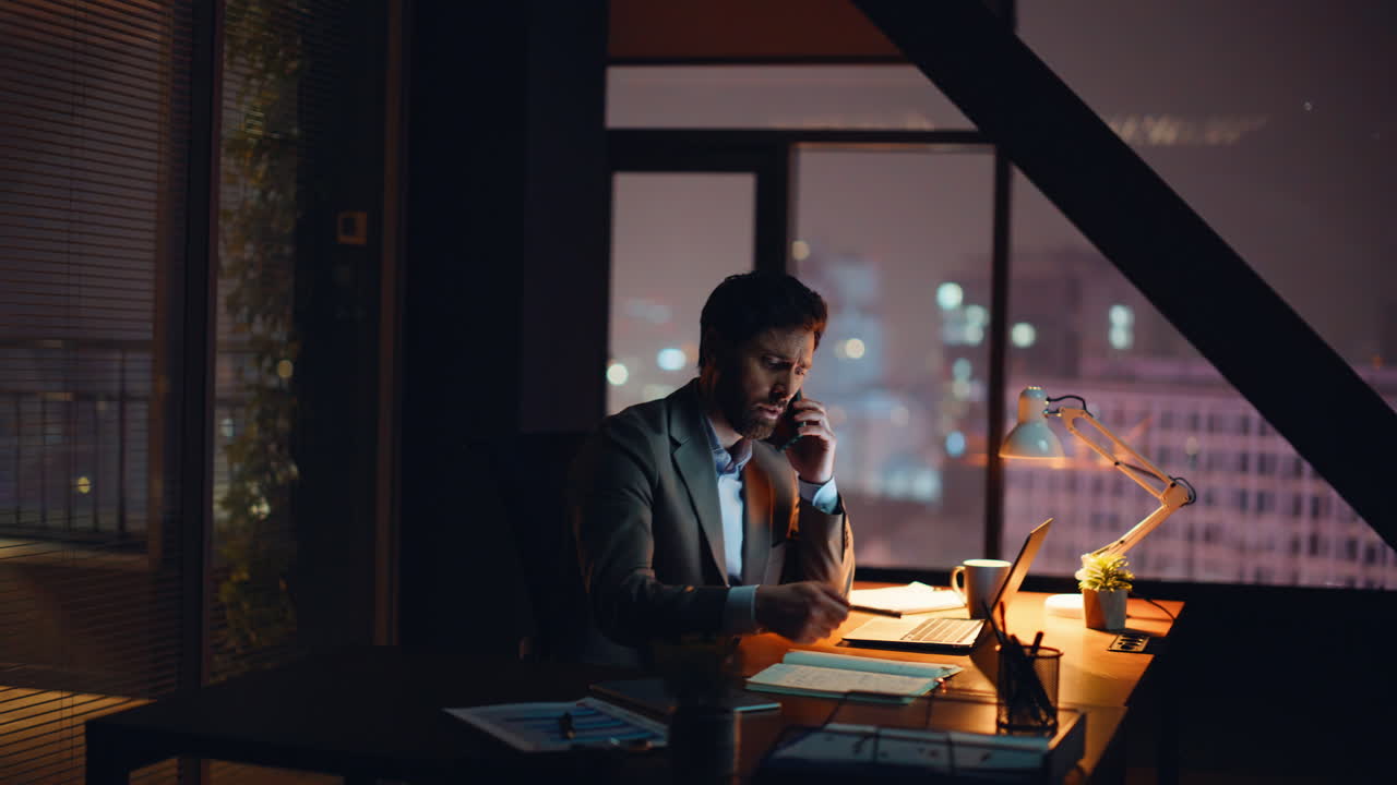 Dirigente che chiama dall'ufficio di notte. Manager preoccupato al telefono