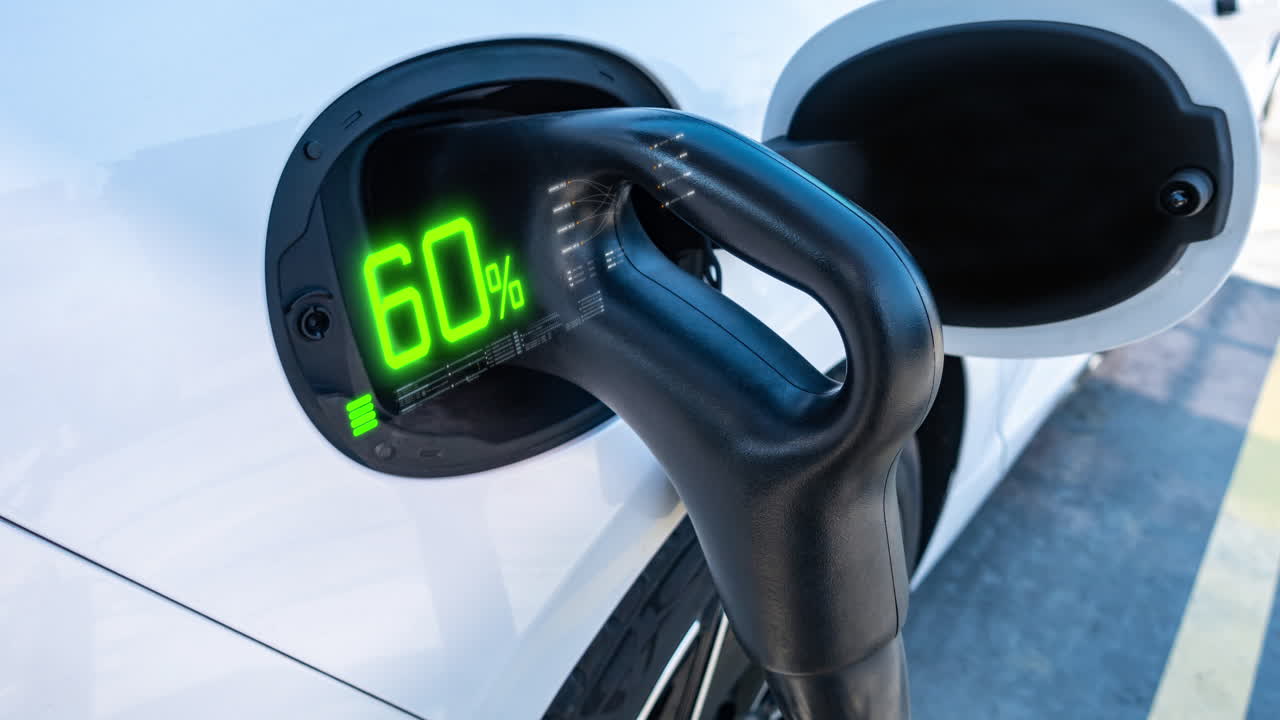 An electric vehicle charging high-voltage energy at an EV charging station replenishes its battery using direct current (DC) power delivered through a charging cable to the vehicle's onboard battery