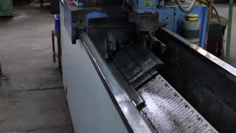 machine putting oil on metal blade in factory