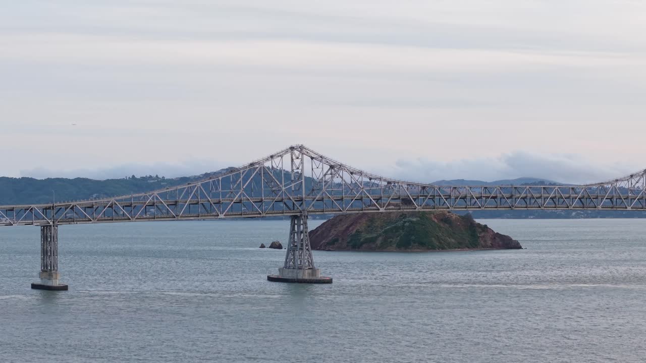 A seagull's perspective of the bridge captures the symmetry and scale of this vital crossing through the bay’s gentle atmosphere.