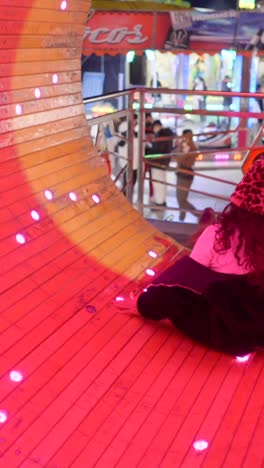 person exploring a vibrant amusement park tunnel with colorful lights
