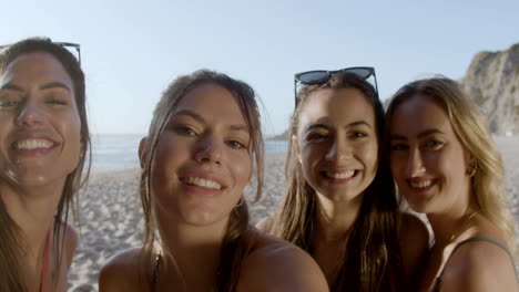 vista frontal de una mujer sonriente tomando una selfie con sus amigas