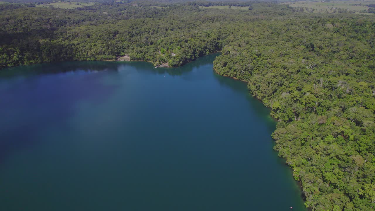 atherton tableland, queensland, australia에 있는 호수 eacham의 차분한 청록색 물 - 공중 드론 샷