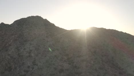 Drohne,-Die-Um-Den-Berg-Herumschwenkt,-Mit-Sonnenuntergang-Dahinter
