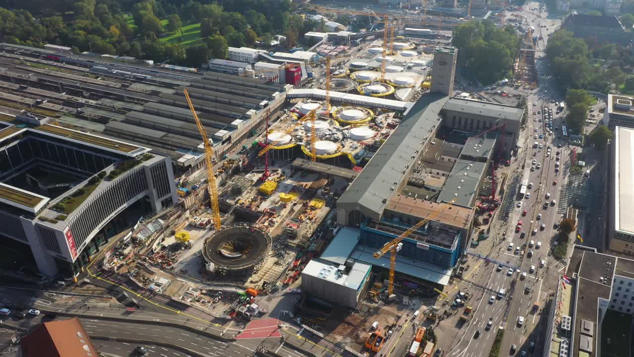 vuelo aéreo sobre enormes vías férreas, intersección y sitio de construcción de la estación principal de trenes stuttgart s21 con grúas y trabajadores de la construcción en stuttgart, alemania